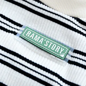 Detailed close-up of black and white striped pet pajamas with a green logo patch