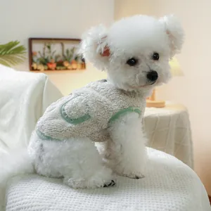 Close-up of warm fleece dog vest with plush texture and green trim in a cozy home setting