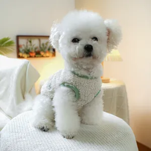 Detail of warm off-white sherpa pet vest with green trim on a Bichon Frise dog
