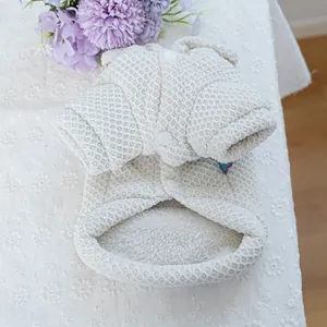 Close-up of quilted white pet hoodie showing soft fleece lining and secure snap buttons