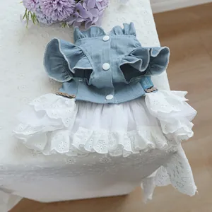 Detail of pet denim dress featuring ruffled shoulders and white lace embroidery layering