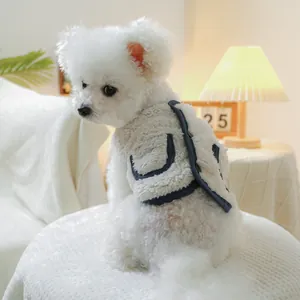 Detail of warm sherpa fleece pet vest with navy trim and pocket on small white dog