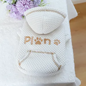 Detail of white waffle texture pet hoodie with gold PLAN embroidery and kangaroo pocket