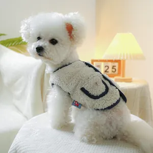 Detail of cream fleece pet vest featuring navy trim and a decorative side pocket