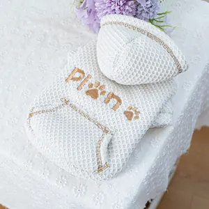 Detail of white waffle pet hoodie with gold embroidery and cozy front pocket