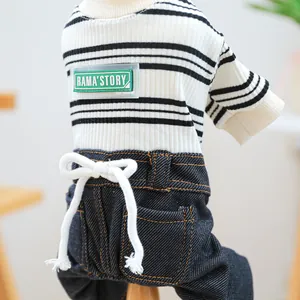 Detail of pet jumpsuit featuring black and white stripes and denim fabric with a white bow