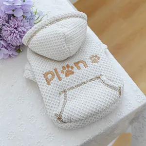 Detail of white waffle knit pet hoodie featuring brown paw embroidery and kangaroo pocket