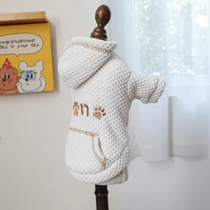 Detail view of cream waffle knit pet hoodie with paw embroidery on a mini mannequin