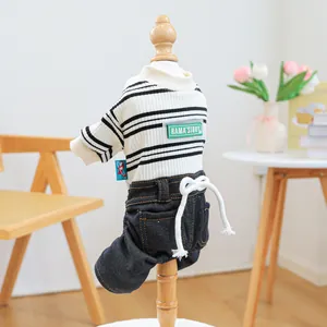 Detail of pet striped knit shirt and denim overalls with green embroidered lettering patch