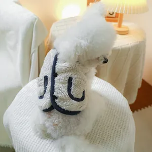 Detail of warm white fleece pet vest with navy blue trim on a small dog model