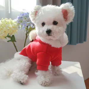 Detail of red Christmas pet hoodie with white faux fur trim and festive bell on dog
