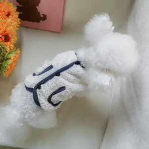 Close-up of warm sherpa pet vest with navy blue trim and buttons on a small dog