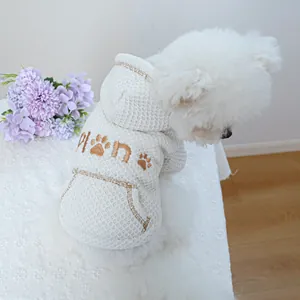 Detail of white waffle texture dog hoodie featuring brown paw embroidery and mini pocket