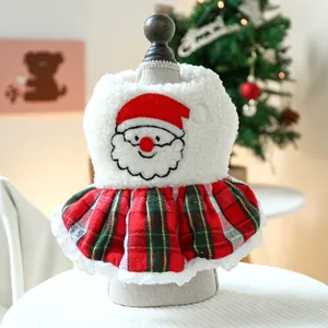 Detail of Christmas pet dress featuring Santa embroidery and red green plaid skirt