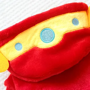 Détail du manteau en peluche rouge pour chien avec sangle brodée jaune et motifs bleus