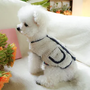 Detail of warm beige fleece pet vest with navy trim and pocket on a small dog