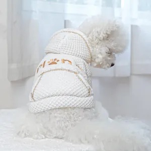 Macro detail of white waffle knit pet hoodie with planet embroidery and paw print on back