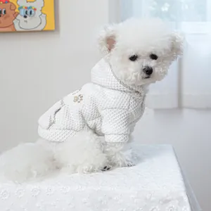 Close-up of white waffle texture pet hoodie with brown paw embroidery and warm fleece lining