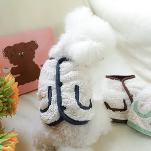 Detail of warm lamb wool pet vest with three-button closure and colorful piping