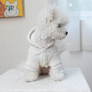 Detail of white waffle texture pet hoodie with secure snap buttons on a fluffy dog
