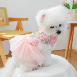 Detail van roze hondentruitje met bloemenborduursel en tule lagen op een Bichon Frisé