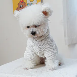 Detailed close-up of white waffle texture pet sweater with buttons on a small dog