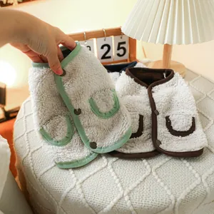 Detail of warm fleece pet vests with soft texture, button closure and pocket accents