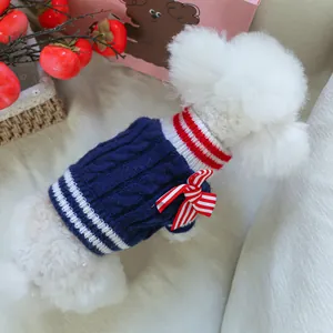 Close-up of navy knit pet sweater with cable texture and red-white bow detail