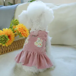 Close-up of pink corduroy pet dress with floral bunny embroidery and metal D-ring for leash