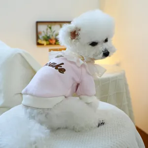 Detail eines rosa Hunde-Sweatshirts mit Cake-Stickerei und Spitzenkragen-Dekor