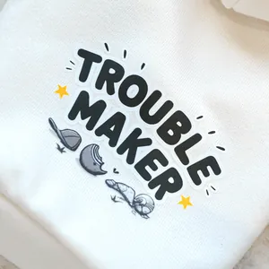 Detailed view of the Trouble Maker lettering and cartoon graphics on a white pet hoodie