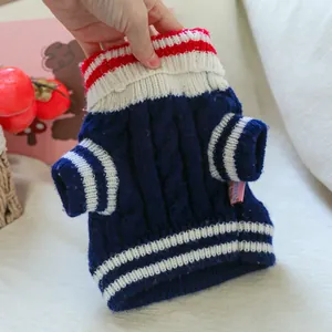 Close-up of a navy pet sweater featuring knitted texture and red white striped cuffs