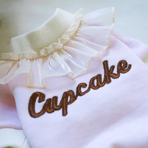 Detail of pink pet cupcake sweatshirt with white organza ruffle collar and embroidery