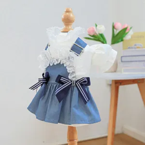 Dettaglio vestito per cani con colletto in pizzo bianco e gonna denim blu con fiocchi