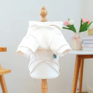 Detail view of cream pet hoodie back on mannequin with soft indoor lighting and flowers