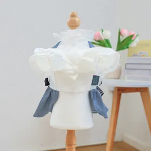 Dettaglio di vestito per cani in denim con corpetto in pizzo bianco e fiocchi a righe