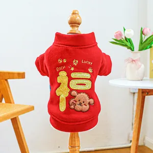Detail of red festive pet hoodie with gold embroidery and warm fleece texture