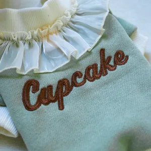 Detailed view of the ruffle mesh collar and cupcake embroidery on the pet sweatshirt
