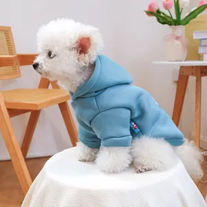 Detail of light blue pet hoodie with woven label shown on a small white dog