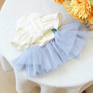 Detailed close-up of light blue mesh tutu skirt and cream knit fabric for small pets