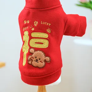 Detail of red festive pet sweater with gold Fu embroidery and plush bear patch
