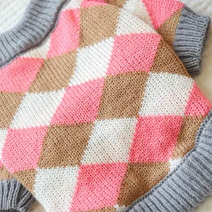 Close-up of pink and brown argyle knit pet sweater with ribbed edges and soft texture