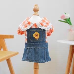Dettaglio di un vestito in denim per cani con motivo a quadri arancioni e ricamo
