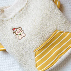 Detail eines weichen Haustier-Sweatshirts mit gelben Streifen und Hundestickerei