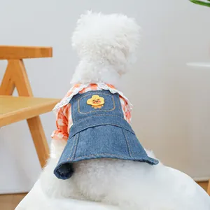 Dettaglio vestito in denim per animali con ricamo floreale e camicia a quadri arancio