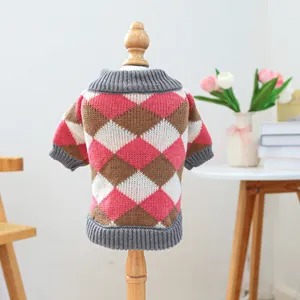Detail of pink and brown argyle knit pet sweater with ribbed grey trim on wood display