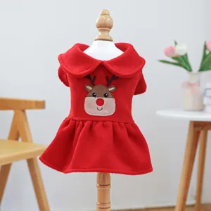 Christmas dog dress in red velvet with reindeer embroidery on a wooden stand display
