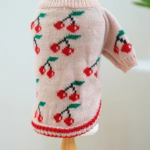 Detail of soft knit pet sweater with cherry jacquard pattern and red ribbed hem edges