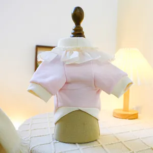 Close-up of pink pet sweater with white ruffle collar detail on a wooden mannequin