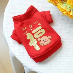 Detail of red pet sweater featuring festive gold embroidery and cute puppy patch